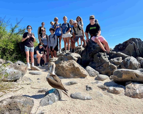 Students gathering behind a Blue Footed Boobie